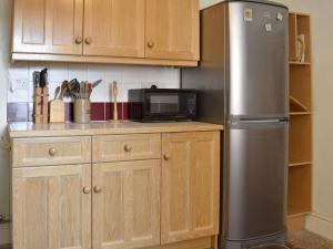 a kitchen with a stainless steel refrigerator and a microwave at The Black Bull in Appleby