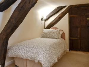 sypialnia z łóżkiem i drewnianymi belkami stropowymi w obiekcie The Black Bull w mieście Appleby