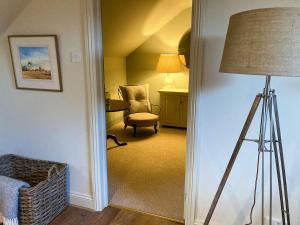 een woonkamer met een lamp en een stoel bij Larkhams Loft in Teffont Magna
