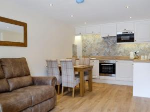 a kitchen and living room with a couch and a table at The Byres Tan in St Bees
