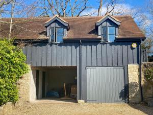 a garage with a white door and two windows at Larkhams Loft in Teffont Magna
