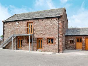 an old brick building with orange doors at The Byres Tan in St Bees