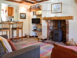 a living room with a fireplace and a stove at Kates Cottage in Slingsby