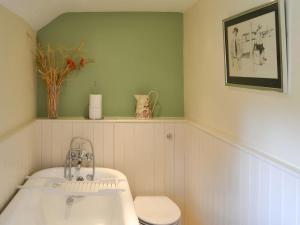a bathroom with a tub and a toilet and a sink at Kates Cottage in Slingsby