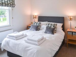 a white bed with towels on top of it at 1 Alexandra Villa in Coltishall