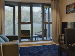 a living room with a couch and a large window at Riverview Apartment in Backbarrow