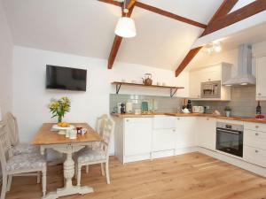 a kitchen with a wooden table and a dining room at The Hayloft - Uk32686 in Sheepstor