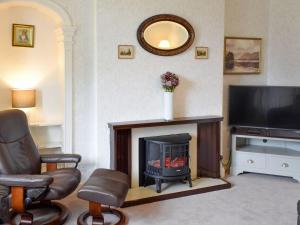 a living room with a fireplace and a television at Tarn House in Wooler