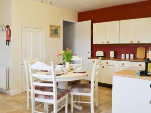a kitchen with a table and chairs in a kitchen at Highbury Farm Cottage in Wharram le Street