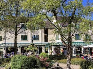 uma grande casa branca com pessoas sentadas fora dela em High Brow em Bowness-on-Windermere