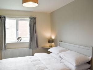 a bedroom with a white bed and a window at Three Dorchester Drive - Uk32039 in Inglewhite