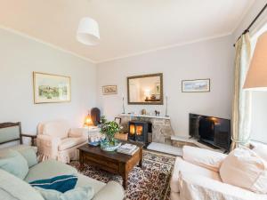 a living room with white furniture and a fireplace at Edmonston Lodge in Elsrickle
