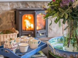 a tray with a bunch of cups and a vase with flowers at Edmonston Lodge in Elsrickle