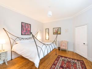 1 dormitorio con cama y alfombra en Edmonston Lodge, en Elsrickle