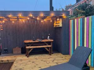 a wooden table and chairs on a patio with a fence at Ballypride in Girvan