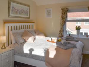 Schlafzimmer mit einem Bett mit einem Tisch und einem Fenster in der Unterkunft Bennys Cottage in Hotham