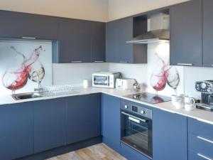 a kitchen with blue cabinets and a sink and a stove at Percy Park Apartment in Tynemouth