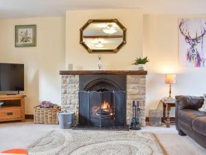 a living room with a fireplace and a mirror at Primrose Bank in Tirril