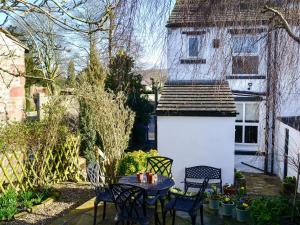 a patio with a table and chairs and a building at Dick n Liddys in Gargrave