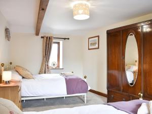 a bedroom with two beds and a mirror at Primrose Bank in Tirril