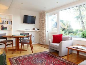 a living room with a couch and a table at Garden Cottage in Icklesham