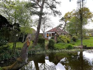 a house sitting next to a body of water at Garden Cottage in Icklesham