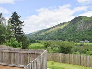 a wooden fence with mountains in the background at Faodail-uk34218 in Aberfoyle