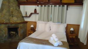 a bedroom with a bed with towels on it at Chalé Bom Jardim in Camanducaia