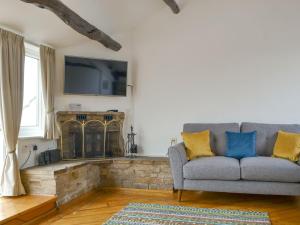 a living room with a couch and a fireplace at Lane Foot Barn in Dean