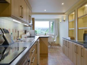 eine Küche mit einem Waschbecken und einem großen Fenster in der Unterkunft Lane Foot Barn in Dean