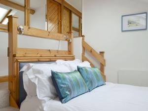 Schlafzimmer mit einem Bett mit weißer Bettwäsche und blauen Kissen in der Unterkunft Lane Foot Barn in Dean