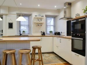 a kitchen with a counter and stools in it at Riverholme in Bassenthwaite