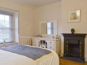 a bedroom with a bed with a fireplace and a mirror at Riverholme in Bassenthwaite