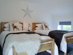 1 dormitorio con 2 camas y una estrella en la pared en Ty Canol, en Llansaint