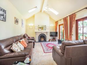 a living room with leather couches and a fireplace at Garden Cottage - Uk34669 in Great Corby