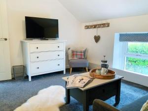 a living room with a tv and a coffee table at Ty Canol in Llansaint