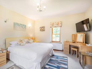 - une chambre avec un lit, un bureau et une télévision dans l'établissement Garden Cottage - Uk34669, à Great Corby
