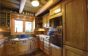 a large kitchen with wooden cabinets and a window at Gorgeous Home In Nol With House Sea View in Nol