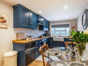 a kitchen with blue cabinets and a table with chairs at The Pavilion in Willoughby