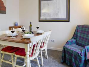 a dining room table and chairs with wine glasses on it at Brae Cottage in Whithorn