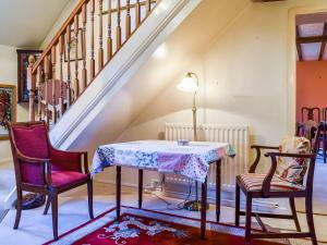 uma mesa e duas cadeiras num quarto com escadas em Saxon Barn em Broom