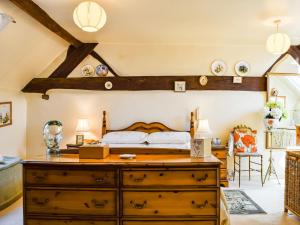 Broom的住宿－Saxon Barn，一间卧室配有一张带木制梳妆台的床