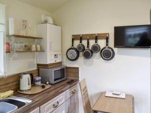 a kitchen with a counter with pots and pans on the wall at Shepherds Hut 1 At Laddingford - Uk32531 in Yalding