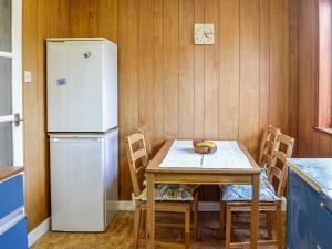 a kitchen with a table and a refrigerator at Ardencaple No 2 in Castle Douglas