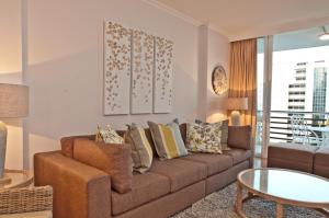 uma sala de estar com um sofá e uma mesa em 506 Lighthouse Mall - by Stay in Umhlanga em Durban