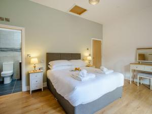 a bedroom with a large white bed with two towels at Y Stabl - Uk12742 in Acrefair