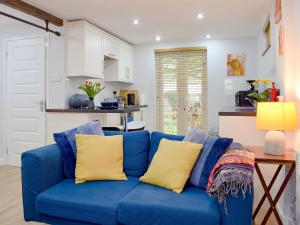 un sofá azul con almohadas amarillas en la cocina en The Studio en Long Hanborough