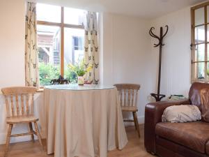 a living room with a table with chairs and a couch at Pepperpot Lodge in Baschurch