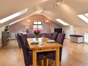a dining room and living room with a table and chairs at Owls Rest in Burley in Wharfedale
