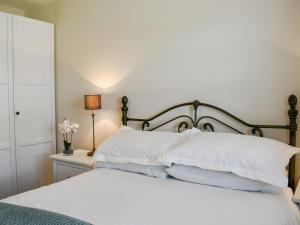 a bedroom with a bed with white pillows at Bank Side in Leyburn